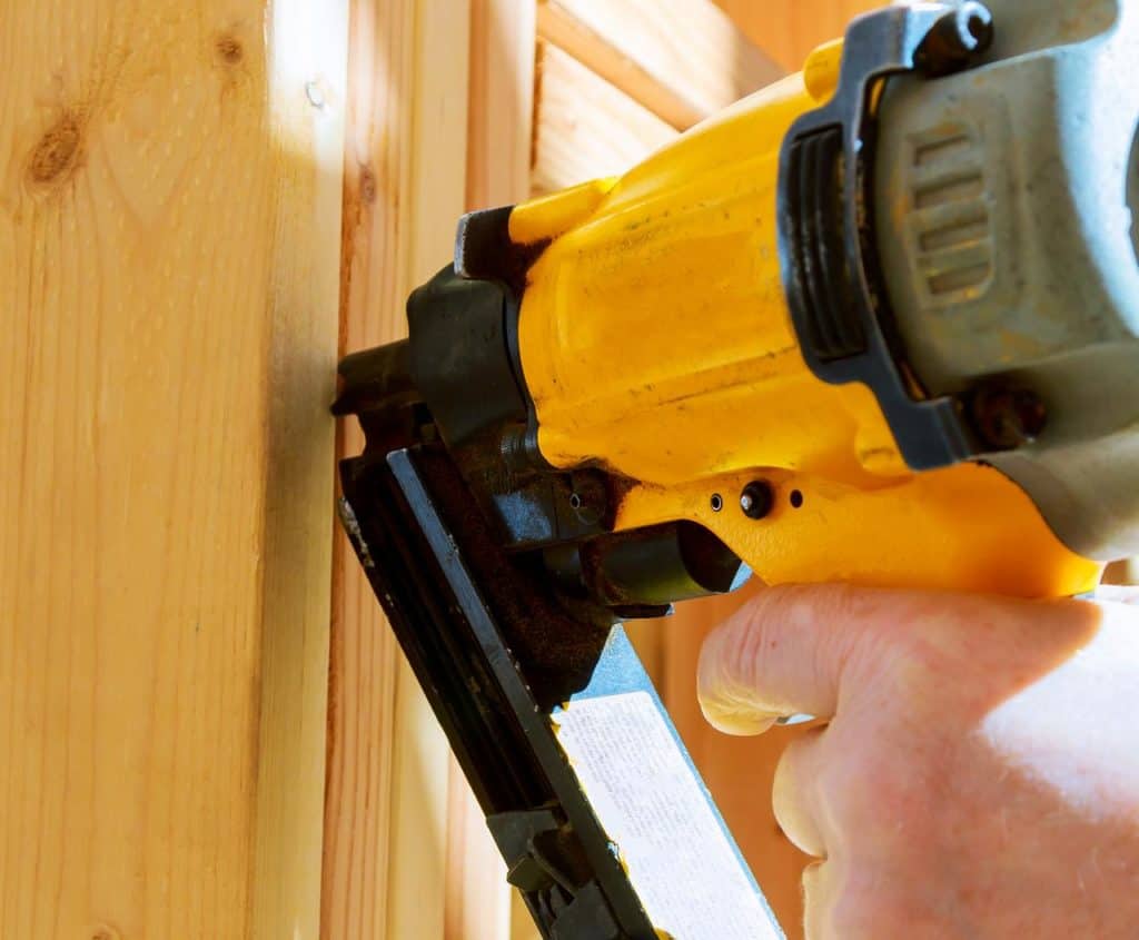 A framing nailer used to drive nails into wooden construction material