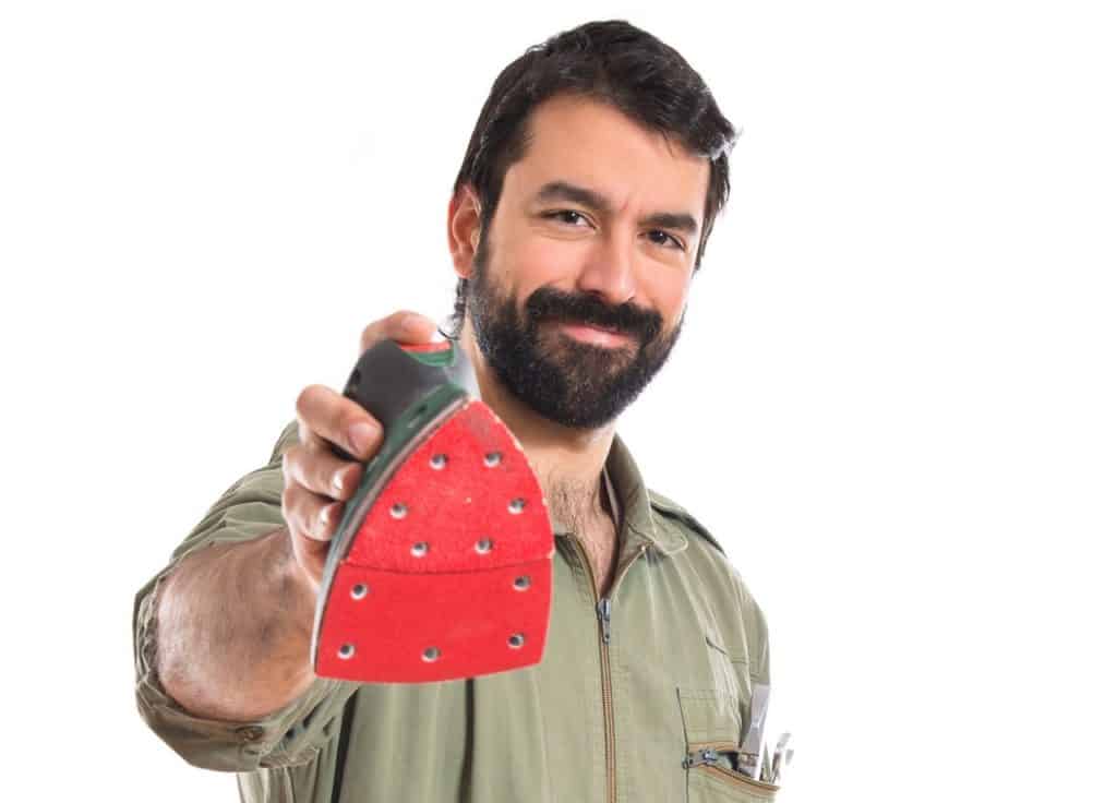 A handyman holding a detail or mouse sander
